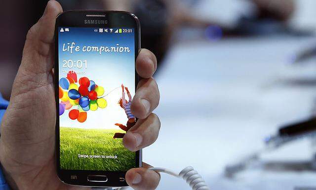A man holds up Samsung Electronics Co´s latest Galaxy S4 phone during its launch at the Radio City Music Hall in New York