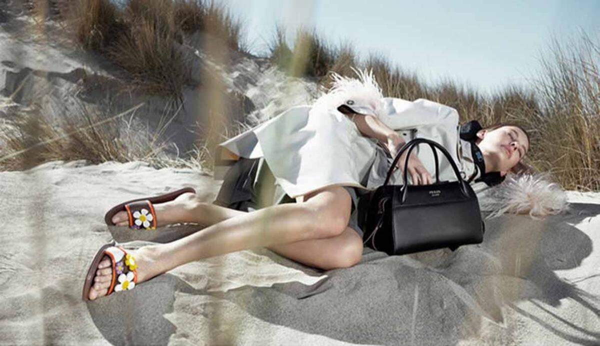 Ein Nickerchen am Strand macht das Model in der Prada-Kampagne von Willy Vanderperre.