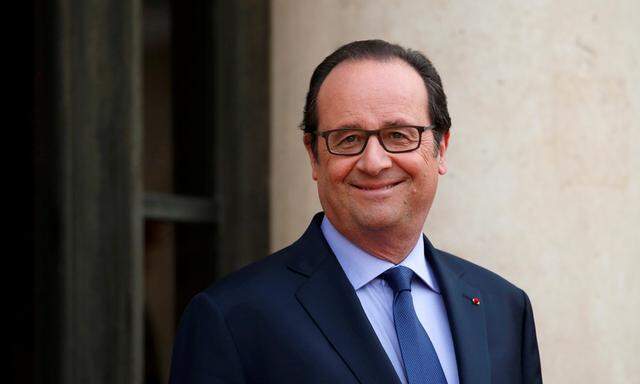 French President Francois Hollande waits for guests outside the Elysee Palace in Paris
