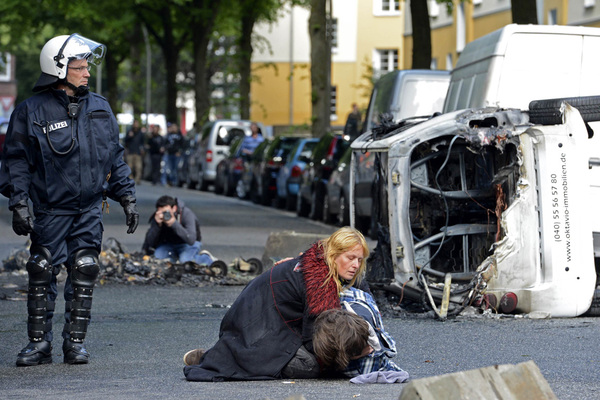 Die radikalen Demonstranten warfen mit Flaschen und Steinen. Auch Fahrzeuge der Einsatzkräfte gerieten in Brand. Hier wird einem Verletzten Hilfe geleistet.