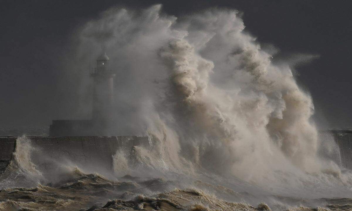 11. Februar. Eine große Welle bricht an der Hafenmauer von Newhaven in Großbritannien.  