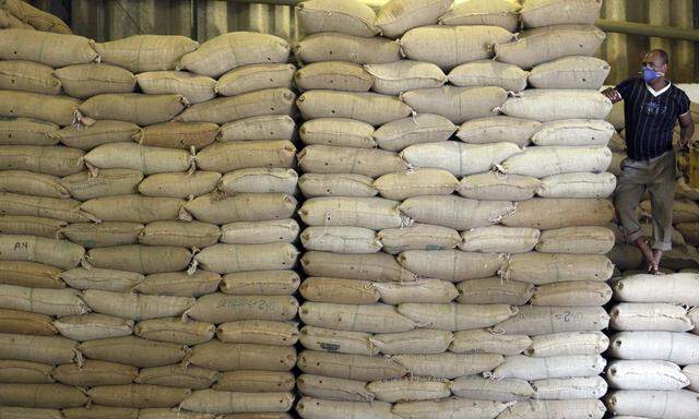 Worker stands next to a sacks of coffee beans at Sumatra factory in Esp?rito Santo do Pinhal