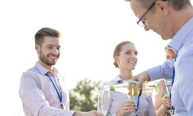 Businessman pouring champagne into glasses on a company party model released Symbolfoto property rel