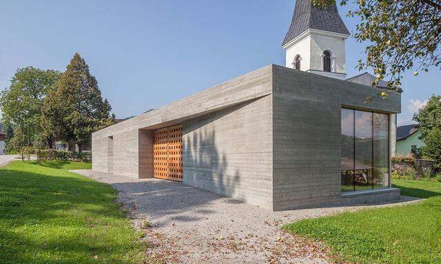 Abgeschirmt gegen die Straße, offen zur Kirche: das neue Pfarrzentrum von Glanhofen und St. Nikolai.