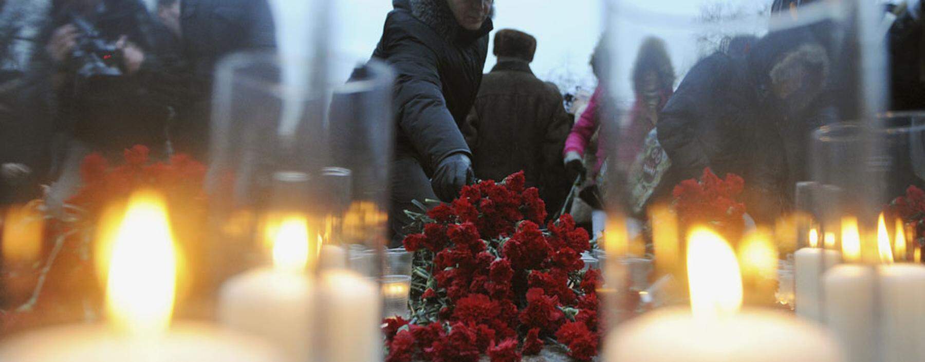 A man lays flowers during a rally to commemorate the victims of a bomb explosion at Domodedovo airport, in central Moscow