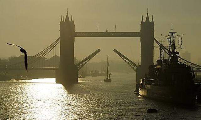 Tower Bridge is opened to let a yacht pass through on the River Thames in London