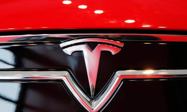 A Tesla logo on a Model S is photographed inside of a Tesla dealership in New York