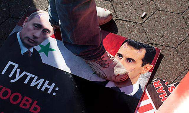 A demonstrator stands on an image of Syrian President Bashar Assads face outside the United Nations 