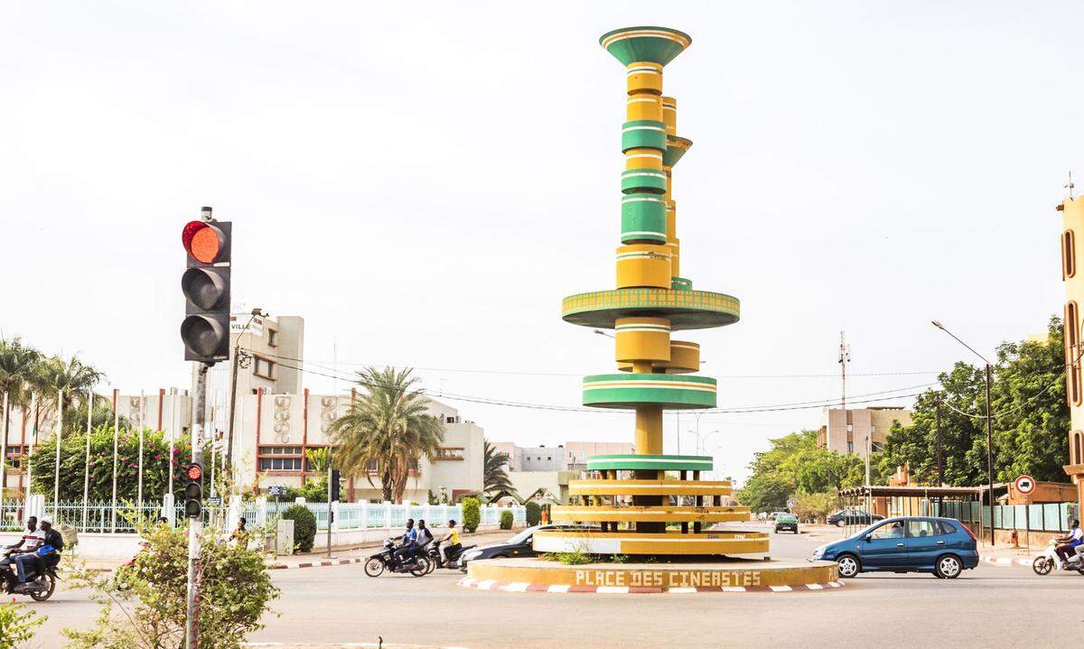 Ein größerer Schlenker nach Norden, weg von der Küste: Binnenland Burkina Faso ist das Ziel des langen Roadtrips nach Österreich. Und dort die Hauptstadt Ougadougou. Das Monument im Kreisverkehr ist übrigens den afrikanischen Filmemachern gewidmet.