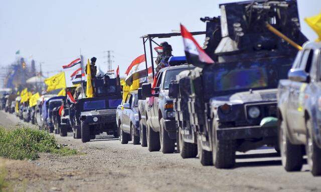 Members of Iraqi security forces and Shiite militia fighters make their way in vehicles from Samarra to the outskirts of Tikrit