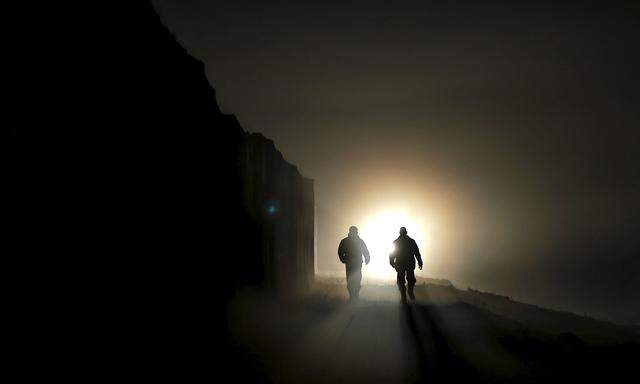 Hungarian soldiers walk along the border fence between Hungary and Croatia