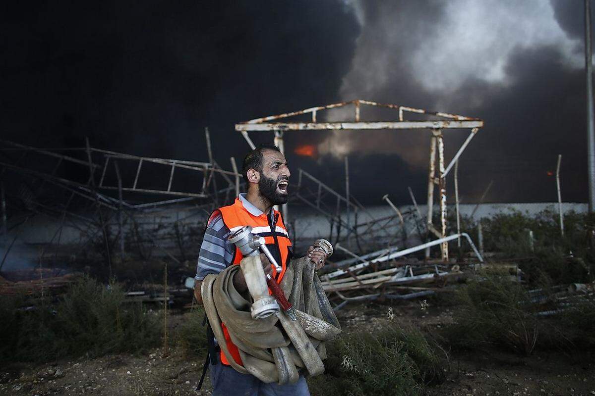 Keine Chance gegen die Flammen. Ein palästinensischer Feuerwehrmann vor dem am Dienstag getroffenen Kraftwerk, das den Gazastreifen mit Strom versorgte.