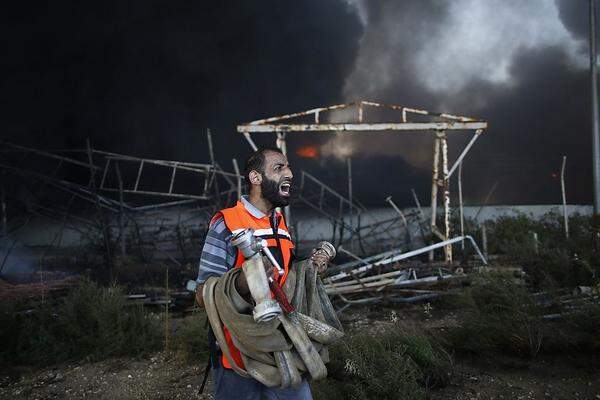 Keine Chance gegen die Flammen. Ein palästinensischer Feuerwehrmann vor dem am Dienstag getroffenen Kraftwerk, das den Gazastreifen mit Strom versorgte.