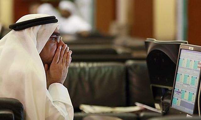 An investors looks at stock exchange information at the Dubai Financial Market