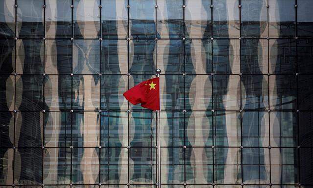 FILE PHOTO: A Chinese national flag flutters at the headquarters of a commercial bank on a financial street in central Beijing