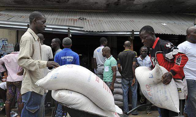 Residents of West Point neighbourhood, which has been quarantined following an outbreak of Ebola, receive food rations from the United Nations World Food Programme in Monrovia