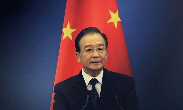 File photo of China's Premier Wen Jiabao standing in front of a Chinese national flag at the Great Hall of the People in Beijing