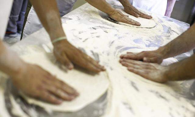 Pizza chefs-in-training students from the 'Master Pizzaioli' school knead pizza dough in Rome