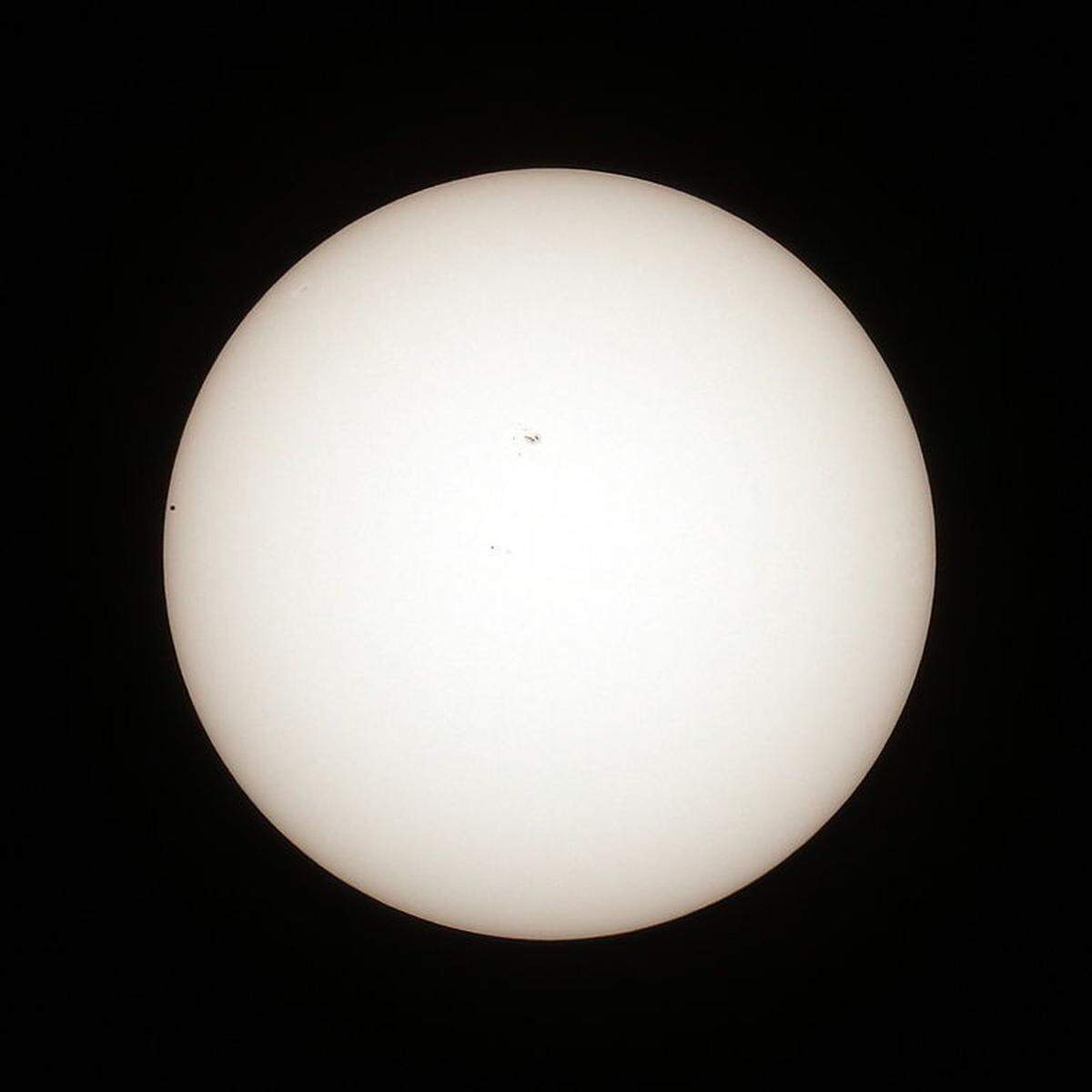 So wie im Augarten war auch die Beobachtungsstation der Wiener Arbeitsgemeinschaft für Astronomie (WAA) auf der Sofienalpe in Wien-Penzing gut besucht. WAA-Obmann Alexander Pikhard war jedenfalls begeistert über das "wunderschöne Sommerwetter", nur ab und zu störten einzelne Wolken die Sicht auf den kleinen schwarzen Punkt vor der Sonnenscheibe und etwa gleich große Sonnenflecken auf der Nordhalbkugel der Sonne. Im Bild: Der Merkurtransit auf einem Foto der Wiener Sofienalpe kurz nach dem Eintritt (Merkur links, Sonnenfleck in der Mitte).