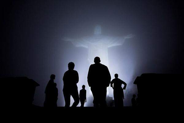 Mystisches Licht hüllt Barack Obama, seine Frau Michelle und Töchter Malia und Sasha vor der Christusstatue Christo Redento in Rio de Janeiro ein. Gerade als die Familie am Gipfel des Corcovado angekommen war, zog sich Nebel vor dem Koloss zusammen.  