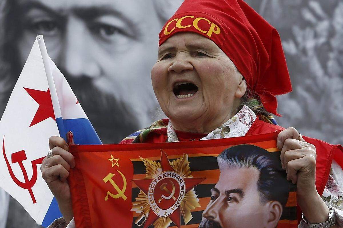 Geordneter waren die Aufmärsche in Moskau: Eine Unterstützerin der Kommunitischen Partei schreit während der friedlichen Straßenzüge Unterstützungsbekundungen. Mit dabei: Josef Stalin auf einem Banner und im Hintergrund Karl Marx.