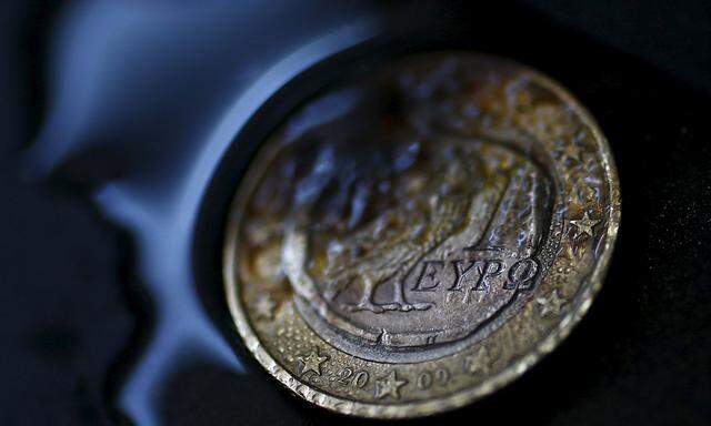A one Euro coin with a Greek owl is seen burning in this picture illustration taken in Hanau