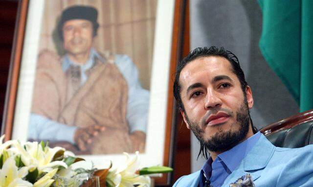 Archivbild von 2005: Saadi Gaddafi vor einem Bild seines Vaters, Muammar al-Gaddafi 