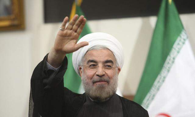 Iranian President-elect Hassan Rohani gestures to the media during a news conference in Tehran