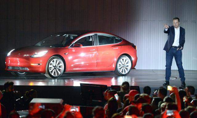 Elon Musk mit dem Hoffnungsauto Teslas, dem Model 3 (im Juli 2017 bei einer Präsentation).