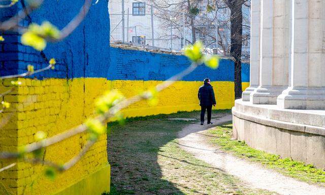 Archivbild vom 1. März 2022. Eine Mauer hinter dem Sowjetdenkmal in Wien erstrahlt in ukrainischen Nationalfarben.