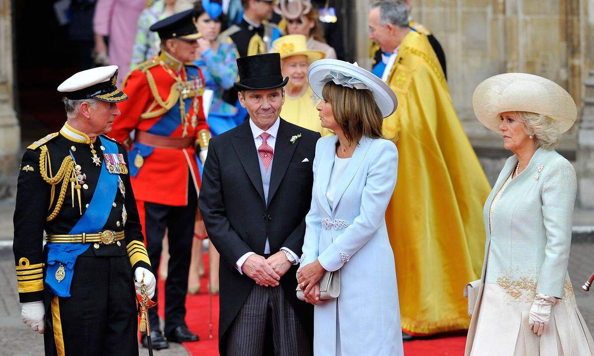 Die Eltern von Prinz William und Herzogin Kate erschienen zur Hochzeit 2011 perfekt gestylt. Prinz Charles trug seine Militärsuniform, Kates Vater Michael trug einen Anzug mit Weste, Krawatte und Hut. Mutter Carole trug über ihrem hellen Kleid einen hellblauen Mantel, dazu den passenden Hut und eine schlichte Halskette. Ihre Clutch und Schuhe waren ebenfalls im gleichen Farbton.