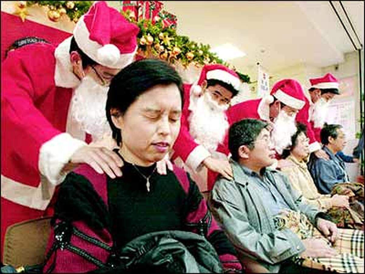 Auf einem elektrischen Massagestuhl stand "Zwängen Sie nie ein Körperteil in die Rückenlehne, wenn die Rotoren laufen".Als "Santa Claus" verkleidete Angestellte massieren Kunden eines Einkaufszentrum anlässlich einer PR-Kampagne in Japan.