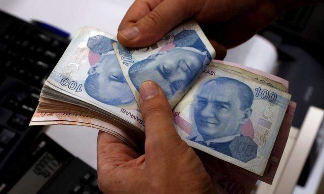 FILE PHOTO: A money changer counts Turkish lira banknotes at a currency exchange office in Istanbul