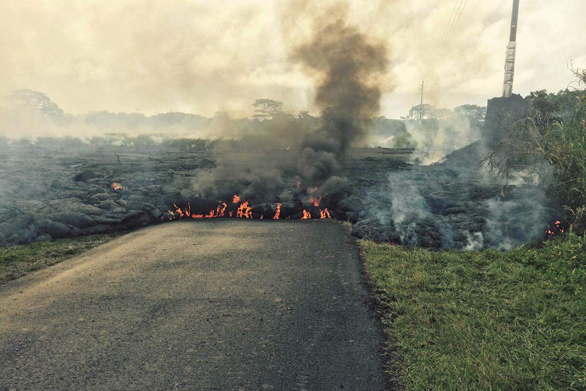 Ein rot glühender Lavastrom frisst sich langsam durch die grüne Landschaft von Hawaii - für die Bewohner der kleinen Ortschaft Pahoa ist er eine bedrohliche Gefahr.