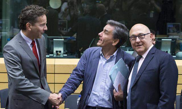 Finance Minister Tsakalotos is welcomed by Eurogroup President Dijsselbloem and French Finance Minister Sapin at a euro zone finance ministers meeting on the situation in Greece in Brussels