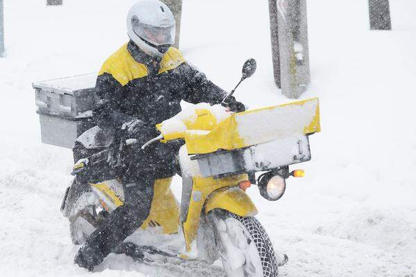 Ein Post-Mitarbeiter müht sich durch den Schnee.