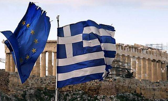 A Greek and an EU flag fly over the Greek ministry of finance in Athens