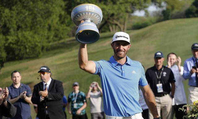 Dustin Johnson of the United States holds up the Walter Hagen trophy after winning the World Golf Ch