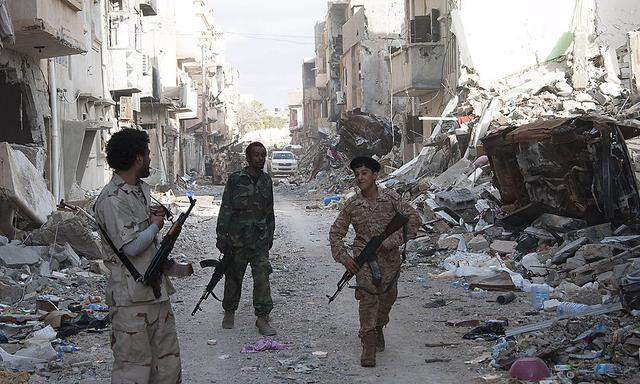 Lybien versinkt immer weiter im Chaos - im Bild ein zerstörter Straßenzug in Benghazi, durchschritten von regierungstreuen Soldaten.
