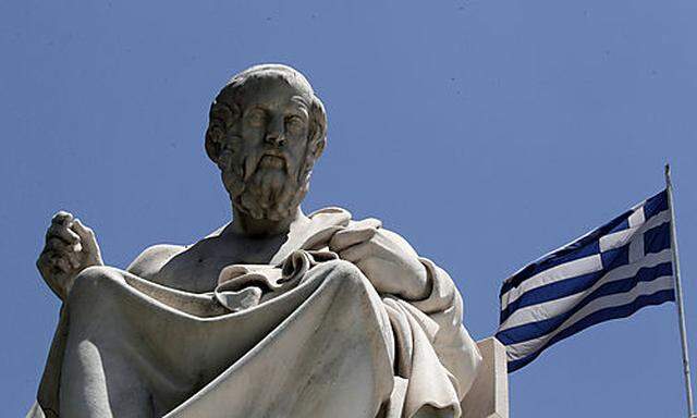 The marble statues of ancient Greek philosophers Plato, stand in front of the Athens Academy, as the 