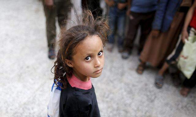 A girl waits for her family's ration at a food assistance center run by volunteers in Sanaa
