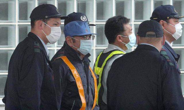 Carlos Ghosn trug beim Verlassen der Haftanstalt eine blaue Kopfbedeckung und einen Mundschutz