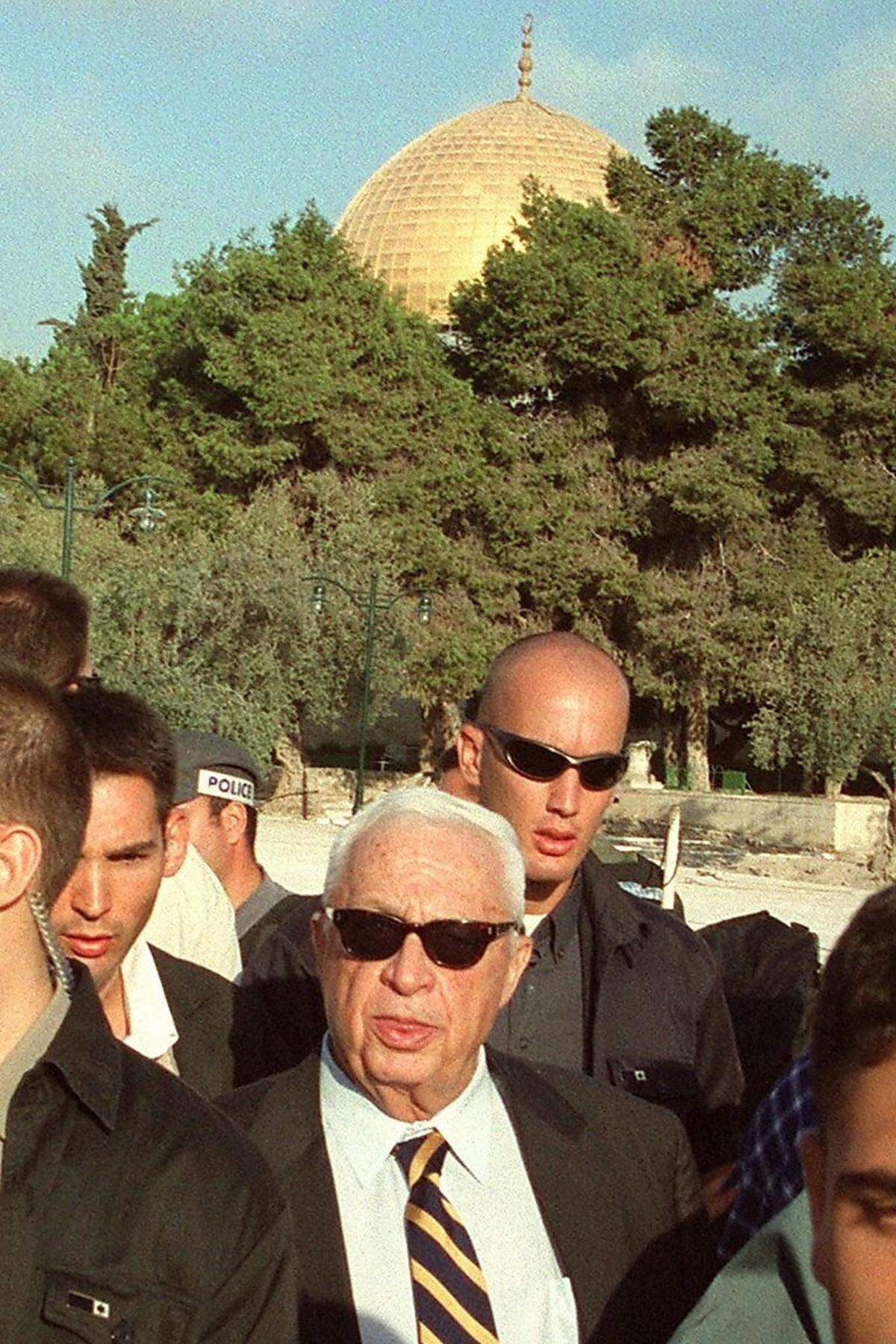 Auf den Krieg folgte die Politik: 1973 wurde Scharon erstmals in die Knesset gewählt. Mehrfach war er in der Folge Minister, unter anderem diente er als Verteidigungsminister, als mit Israel verbündete Milizen im Libanon Massaker in palästinensischen Flüchtlingslagern begingen. Das Bild zeigt den damaligen Oppositionsführer 2000 bei einem umstrittenen Besuch auf dem Tempelberg in Jerusalm, der als Auslöser der Zweiten Intifada gilt.