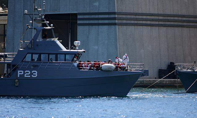 A patrol boat carrying migrants rescued by the Alan Kurdi vessel enters the Maltese harbour