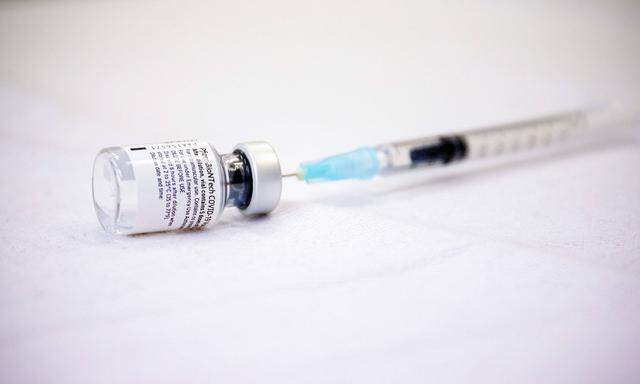 Eine Impfspritze steckt in einer Ampulle mit dem Impfstoff gegen Covid-19 von Pfizer-BioNTech.