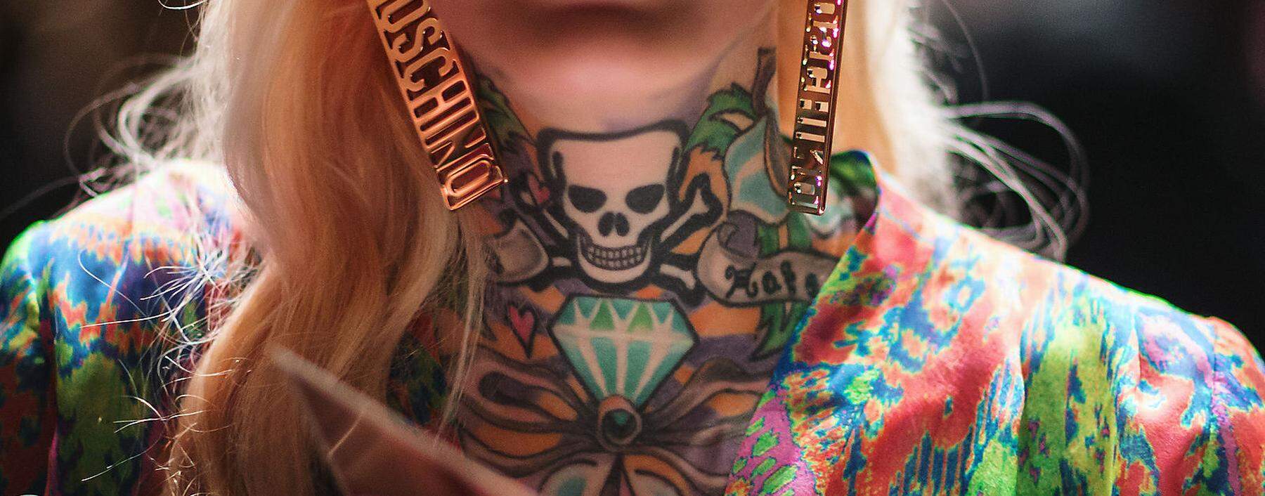 A tattooed women follows the show of designer Lena Hoschek at the Berlin Fashion Week Autumn/Winter 2015 in Berlin