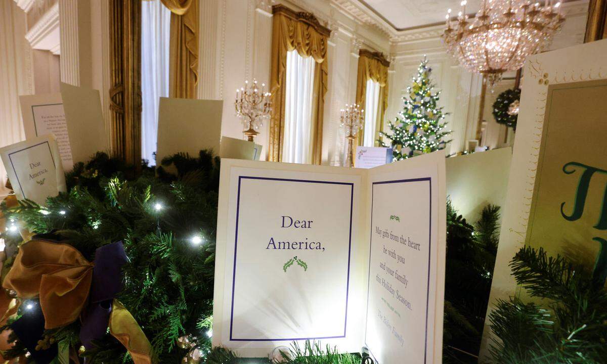 Im East Room wünscht die Familie Biden mittels übergroßer Karte frohe Weihnachten und Geschenke, die von Herzen kommen.