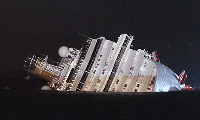 The luxury cruise ship Costa Concordia leans on its side after running aground the tiny Tuscan island