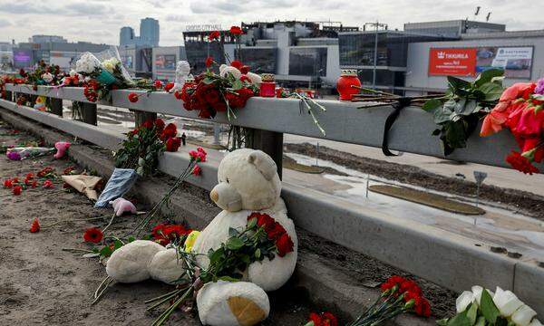 Blumen und Stofftiere zum Gedenken an die Terroropfer vor der ausgebrannten Konzerthalle.