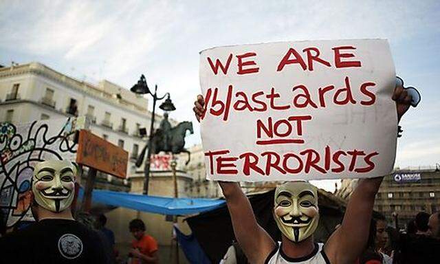 Demonstrators wearing Anynomous group masks protest at Madrids landmark Puerta del Sol s landmark Puerta del Sol 